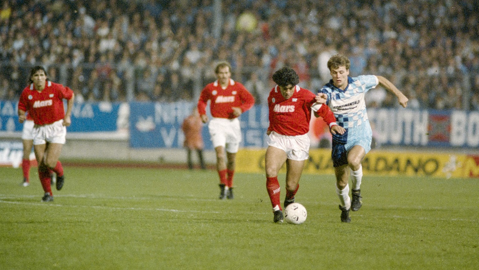 Diego Maradona, zweiter von rechts, vom SSC Napoli zieht waehrend des UEFA Cup Spiels gegen den FC Wettingen von den Wettinger Spielern mit dem Ball Richtung Tor, aufgenommen am 17. Oktober 1989 im Le ...