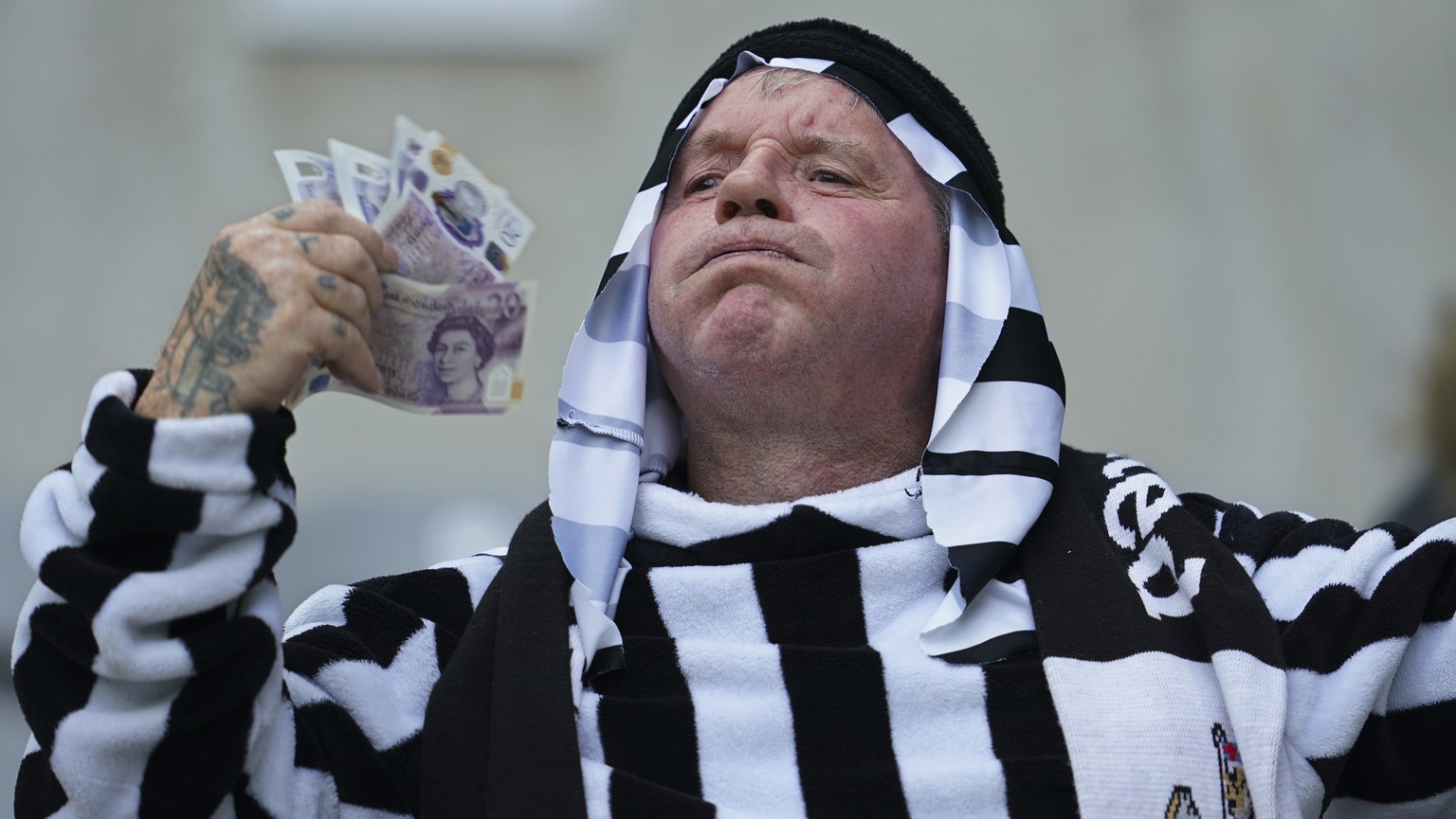 A Newcastle fan waves some notes around before the start of an English Premier League soccer match between Newcastle and Tottenham Hotspur at St. James&#039; Park in Newcastle, England, Sunday Oct. 17 ...