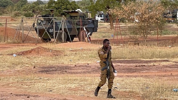 A Burkinabe soldier walks past a French armored car that is part of a French military convoy heading to Niger, stopped by protesters in Kaya, Burkina Faso, Saturday, November 20, 2021. Residents of…