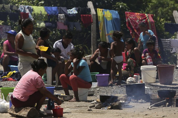 In this March 10, 2018 photo, Waraos from Venezuela prepare meals in an outdoor area of a shelter in Pacaraima, the main entry point for Venezuelans, in the Brazilian northern state Roraima. (AP Photo ...