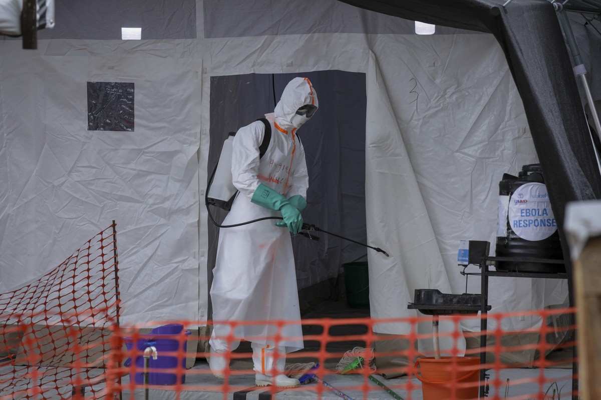 FILE - A medical worker disinfects a tent used for suspected Ebola victims inside the Ebola isolation center of Madudu Health Center III, in the village of Madudu, in the Mubende district of Uganda Tu ...