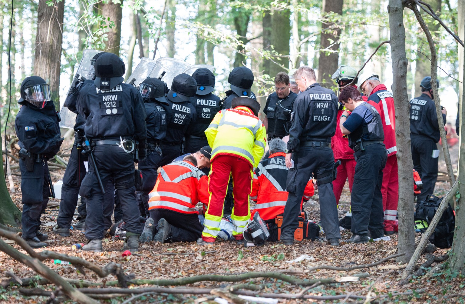 dpatopbilder - 19.09.2018, Nordrhein-Westfalen, Kerpen: Notaerzte versorgen einen Mann, der von einem Baumhaus im Hambacher Forst gefallen ist. Der Mann ist waehrend der Raeumungsarbeiten von einem Ba ...