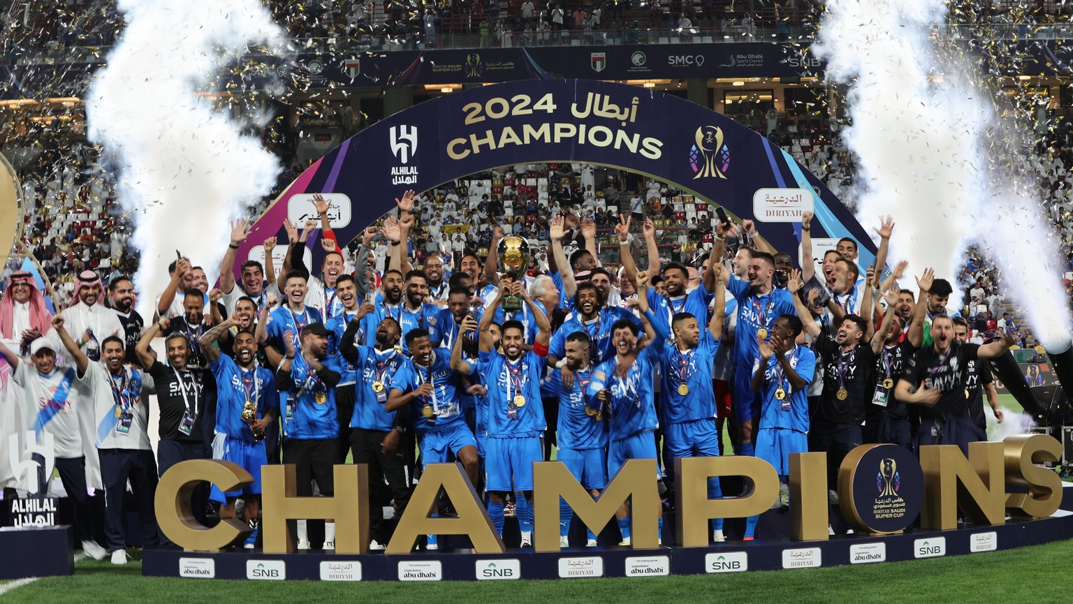 epa11273770 Salem Al-Dawsari (C) of Al-Hilal lifts the trophy on the podium after winning the Saudi Super Cup final between Al-Ittihad and Al-Hilal in Abu Dhabi, United Arab Emirates, 11 April 2024. E ...