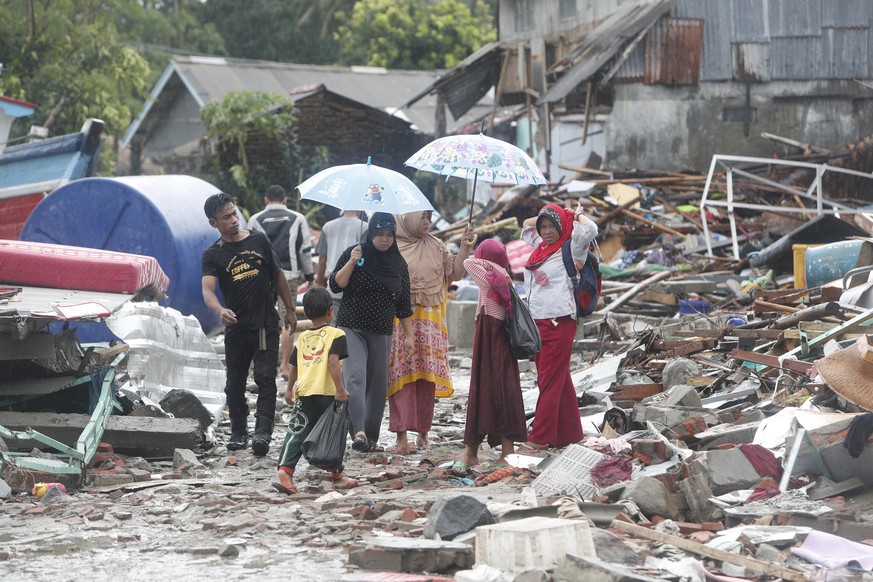 epa07247336 Local residents walk among debris after a tsunami hit Sunda Strait in Sumur, Banten, Indonesia, 24 December 2018. According to the Indonesian National Board for Disaster Management (BNPB), ...