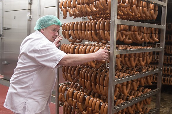 Gestelle mit Cervelats werden aus einer Koch- und Raeucherkammer geschoben beim Fleischverarbeiter Bell in Basel am Montag, 16. Februar 2015. (KEYSTONE/Georgios Kefalas) ** NO SALES, NO ARCHIVES **