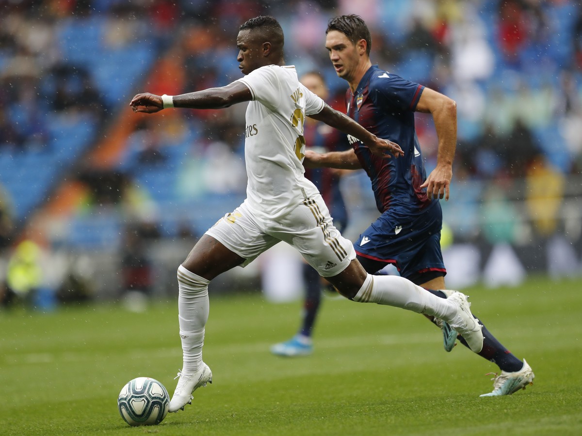 Real Madrid's Vinicius Junior, left, controls the ball during the Spanish La Liga soccer match between Real Madrid and Levante at the Santiago Bernabeu stadium in Madrid, Spain, Saturday, Sept. 1 ...