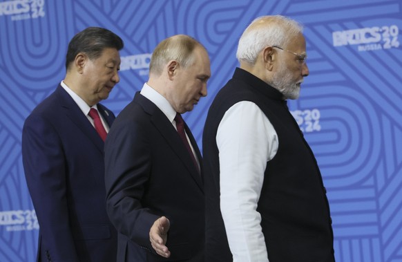 From left: Chinese President Xi Jinping, Russian President Vladimir Putin and Indian Prime Minister Narendra Modi attend a family photo ceremony prior to the BRICS Summit plenary session in Kazan, Rus ...
