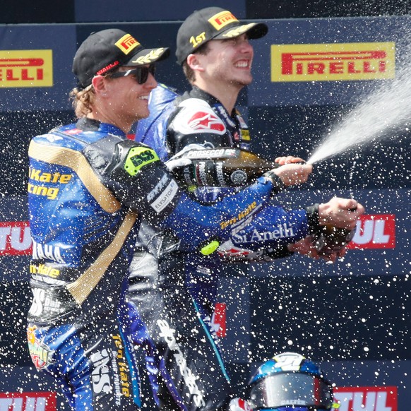 epa09880306 Italian superbike rider Lorenzo Baldassarri, of Yamaha team (R-1st), and his teammate, Swiss Dominique Aegerter (L-2nd), celebrate on the podium during the Aragon Round of the 2022 FIM Sup ...