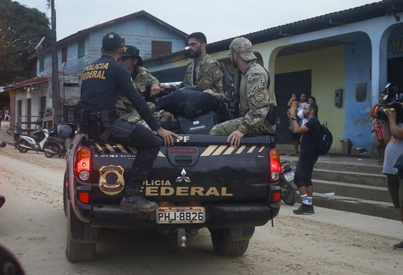 Federal police officers ride on the back of a truck carrying items found during a search for Indigenous expert Bruno Pereira and freelance British journalist Dom Phillips in Atalaia do Norte, Amazonas ...