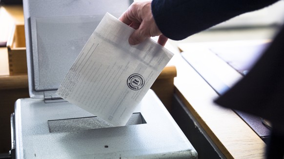 Eine Waehlerin wirft ihren Wahlzettel fuer die Erneuerungswahl der 35 zuercherischen Mitglieder des schweizerischen Nationalrates, Wahl vom 18. Oktober 2015, in die Wahlurne auf einem Kreisbuero der S ...