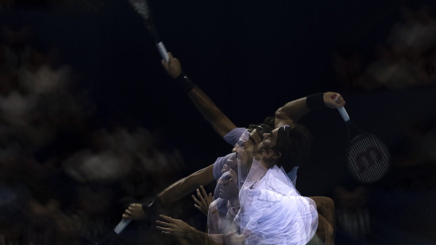 Multiple exposure of Switzerland&#039;s Roger Federer serving a ball to France&#039;s Benoit Paire during their round of sixteen match at the Swiss Indoors tennis tournament at the St. Jakobshalle in  ...