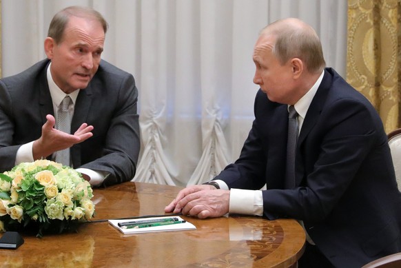 FILE- In this photo taken on, Thursday, July 18, 2019, Russian President Vladimir Putin&#039;s closest associates, Ukrainian tycoon Viktor Medvedchuk, left, speaks to Russian President Vladimir Putin  ...