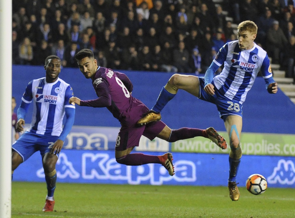 Wigan's Jay Fulton, right, duels for the ball with Manchester City's Ilkay Gundogan during the English FA Cup fifth round soccer match between Wigan Athletic and Manchester City at The DW St ...