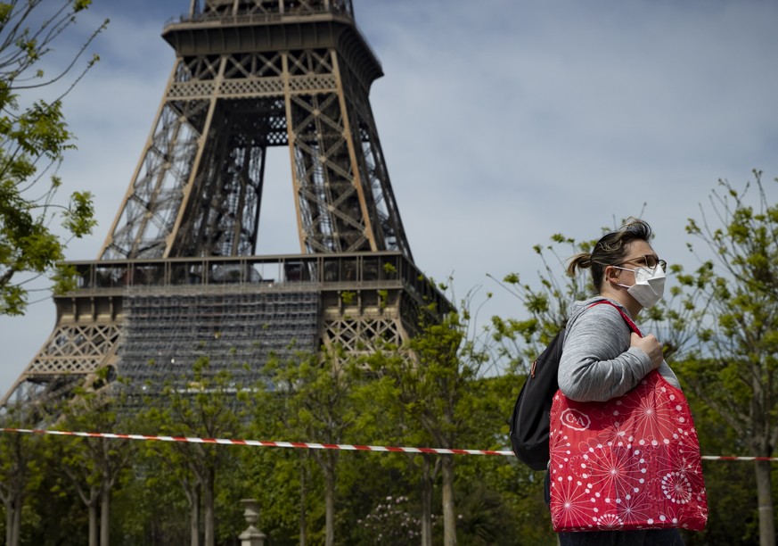 epa08375423 A woman passes by the police cordoned off Champs de Mars parc near Eiffel Tower, in Paris, France, 21 April 2020. France is under lockdown in an attempt to stop the widespread of the SARS- ...