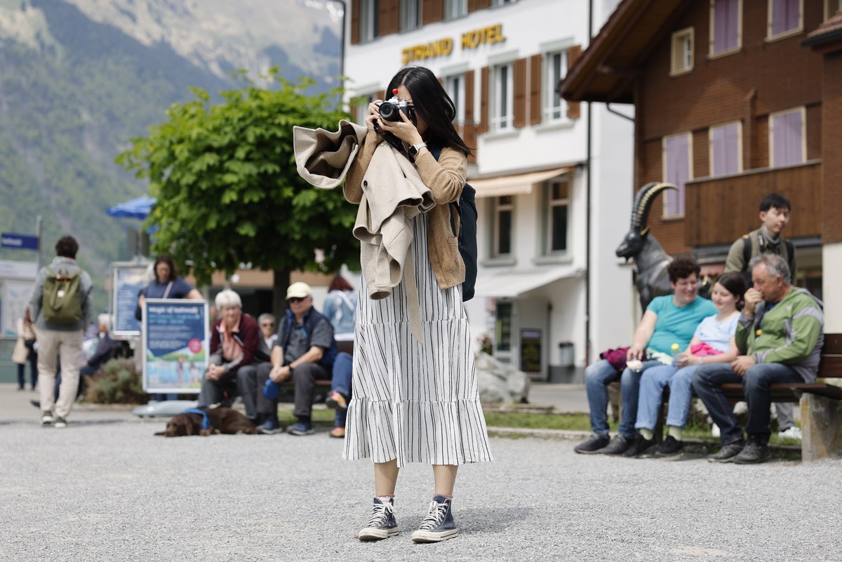 epa10643846 A Korean visitor takes pictures in Iseltwald, Switzerland, 21 May 2023. Lots of Asian TV fans and tourists visit the place because of the romantic Korean Netflix drama 'Crash Landing  ...