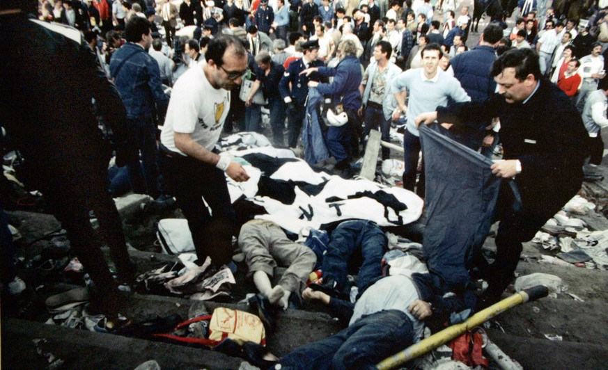 Spectators and police cover bodies with banners and blankets after a disastrous clash between rival soccer fans at the European Cup Final at the Heysel Stadium in Brussels in this Wednesday May 29, 19 ...