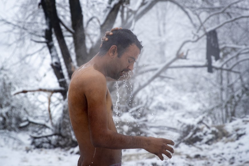 Aftab Tariq, 27, from Pakistan, takes a shower at the Vucjak refugee camp outside Bihac, northwestern Bosnia, Tuesday, Dec. 3, 2019. A top European human rights official has demanded immediate closure ...