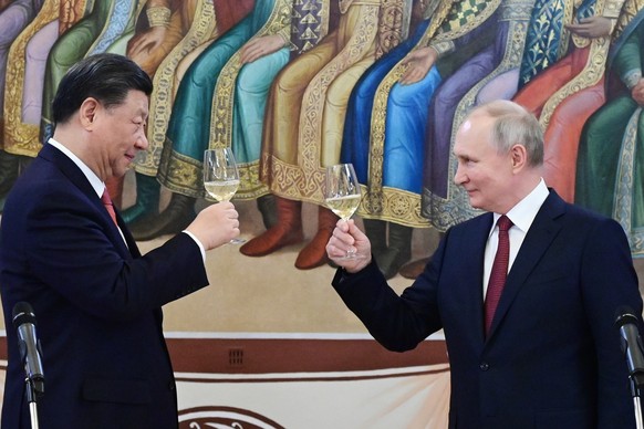 Russian President Vladimir Putin, right, and Chinese President Xi Jinping toast during their dinner at The Palace of the Facets is a building in the Moscow Kremlin, Russia, Tuesday, March 21, 2023. (P ...