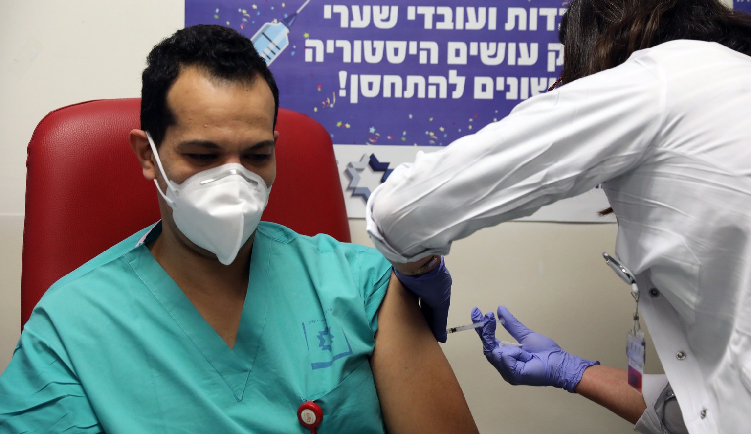 epa08895084 A medical staff of the Shaare Zedek Medical Center receives a dose of the Pfizer-BioNTech COVID-19 vaccine at Shaare Zedek Medical Center in Jerusalem, Israel, 20 December 2020. Israel beg ...