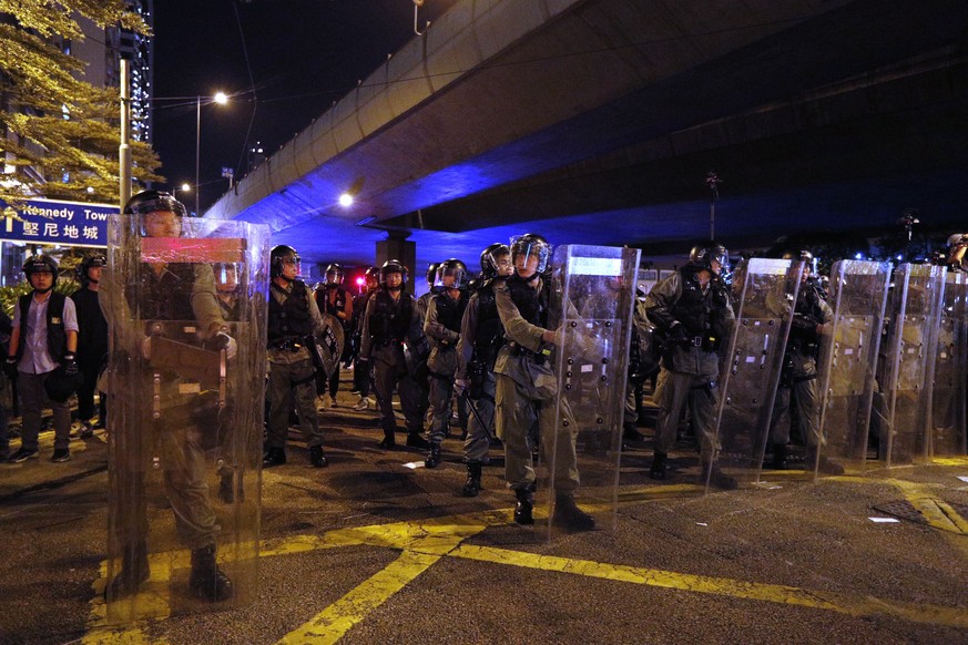 Riot police line up outside the Liaison Office in Hong Kong, Sunday, July 21, 2019. Protesters in Hong Kong pressed on Sunday past the designated end point for a march in which tens of thousands repea ...