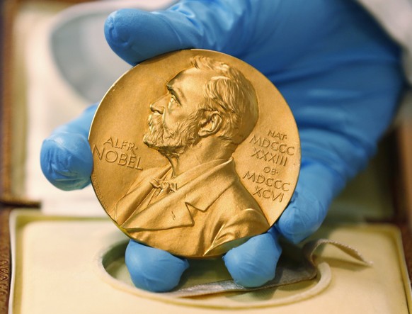 FILE- In this file photo dated Friday, April 17, 2015, a national library employee shows the gold Nobel Prize medal awarded to the late novelist Gabriel Garcia Marquez, in Bogota, Colombia. Swedish la ...