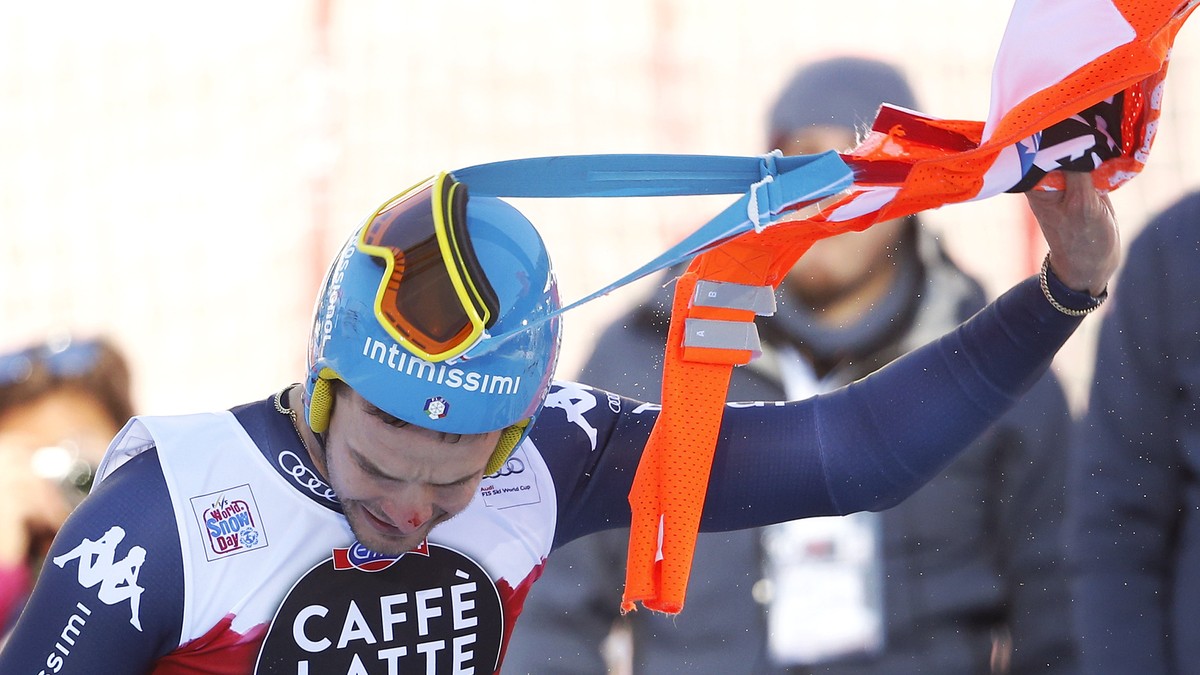Christof Innerhofer of Italy removes part of a gate that remained entrapped in his race glasses after crossing the finish line of the men's downhill race at the Alpine Skiing World Cup in Santa C ...