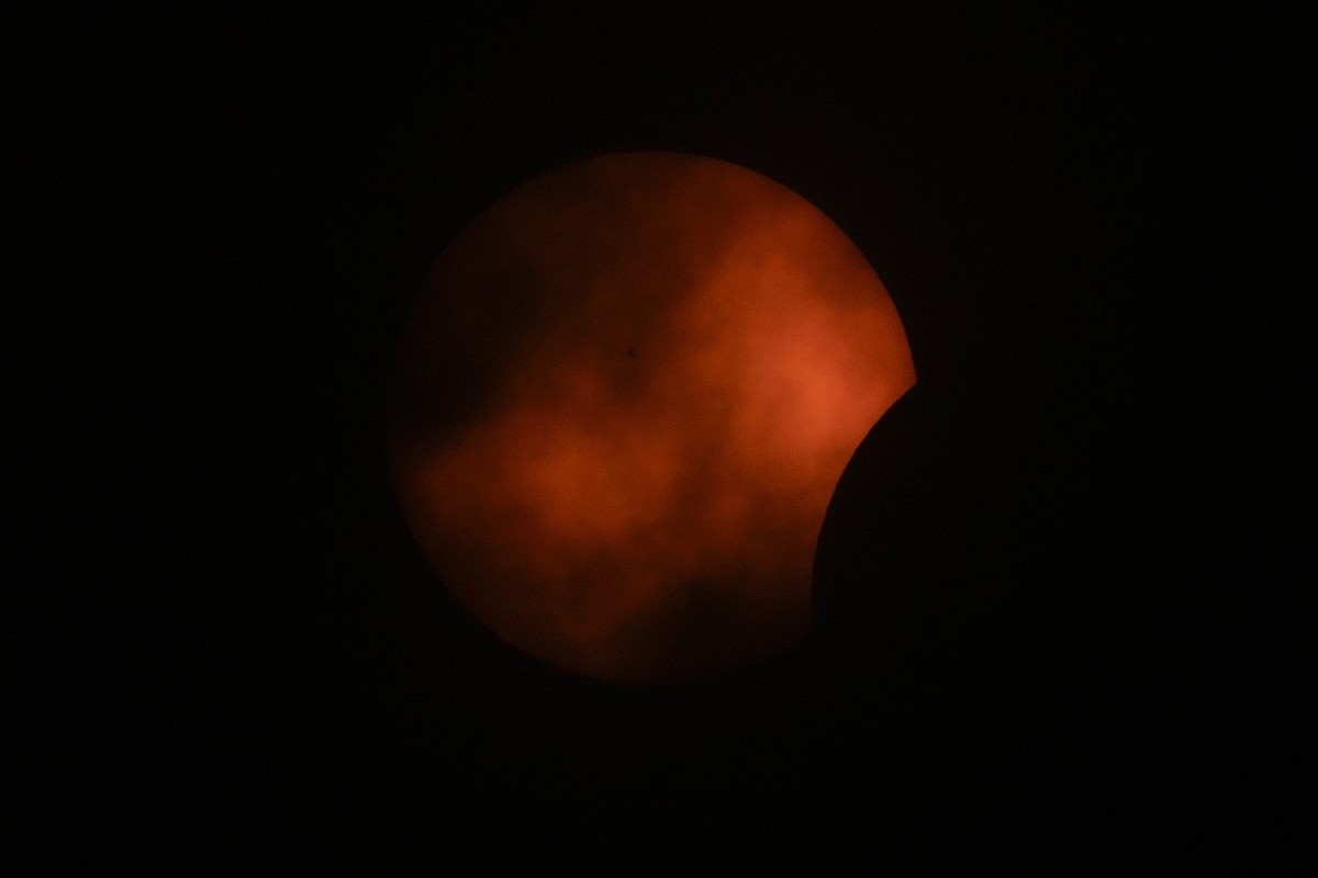 Clouds roll by as the beginning phase of a total solar eclipse is visible from Arlington, Texas, Monday, April 8, 2024. (AP Photo/Julio Cortez)