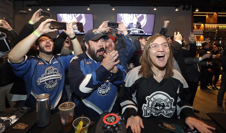 Ryan Kelly, left, Otto Rogers and Rebecca Moloney cheer the announcement of a new NHL hockey team in Seattle at a celebratory party Tuesday, Dec. 4, 2018, in Seattle. The NHL Board of Governors unanim ...