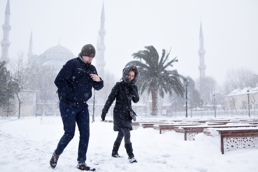 People walk in the snow, in the historic Sultanahmet district in Istanbul, Saturday, Jan. 7, 2017. Heavy snow clogged roads, shipping traffic in Bosphorus and forced hundreds of flight cancellations i ...