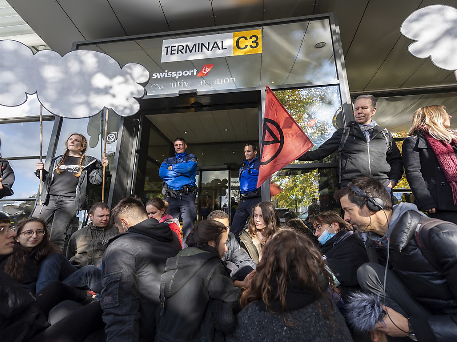 Rund 100 Aktivisten der Extinction Rebellion blockieren die Zufahrtsstrassen zum Privatjet-Terminal des Genfer Flughafens.