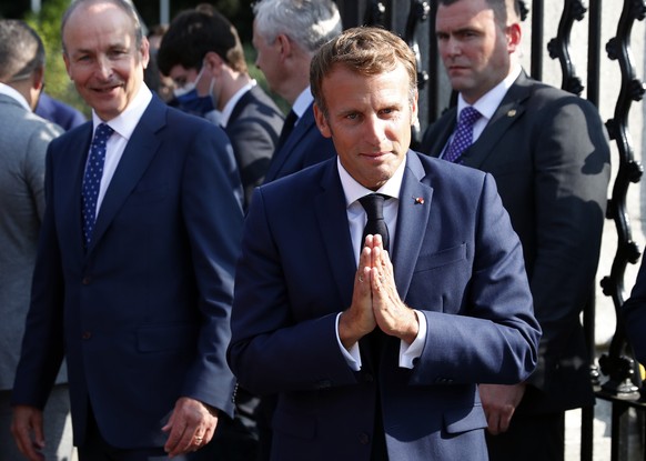 French president Emmanuel Macron thanks musicians as Irish Prime Minister Micheal Martin looks on during a walk through Dublin city centre, Ireland, Thursday, Aug. 26, 2021. French President Emmanuel  ...