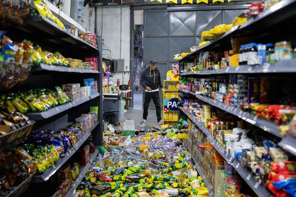 epa13062570 A person looks at spilled groceries at a warehouse in Caracas, Venezuela, 24 June 2026. Two powerful earthquakes struck Venezuela, including a magnitude 7.5 earthquake, causing buildings t ...