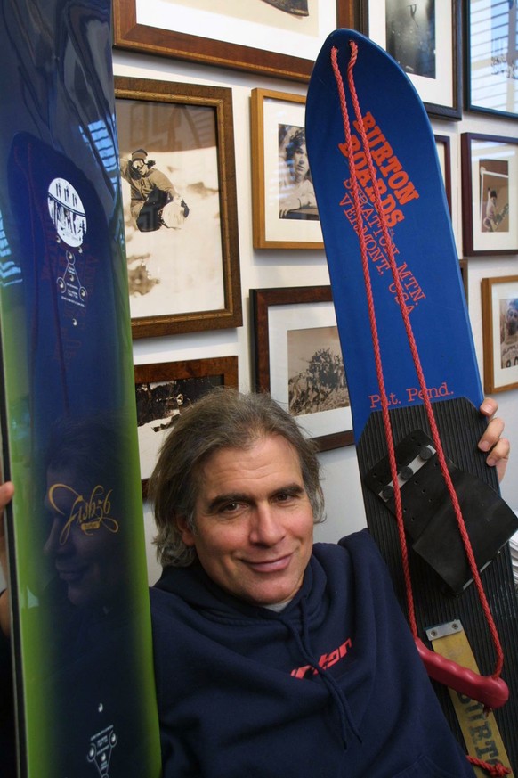 FILE - In this March 8, 2002, file photo, Jake Burton Carpenter, owner of Burton Snowboards, shows an early model, right, and one of the newer snowboards, left, in his office in Burlington, Vt. Carpen ...