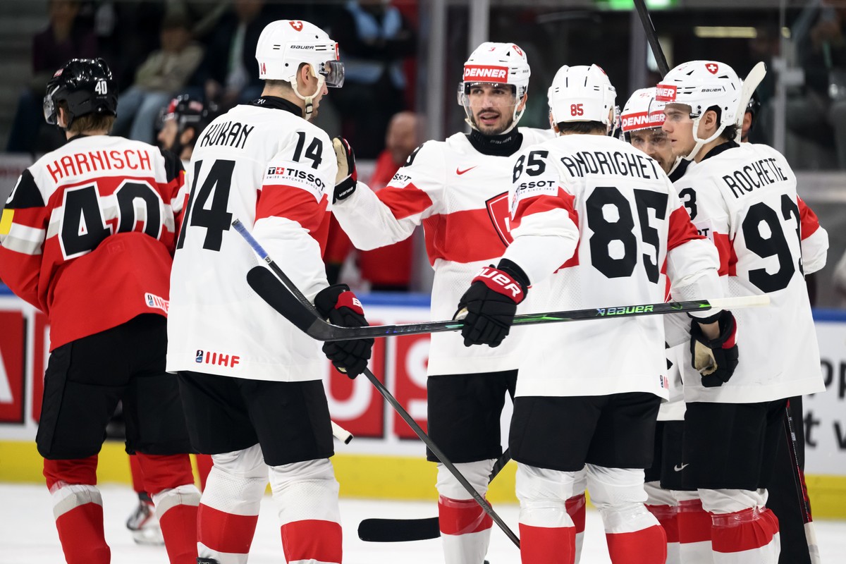 From right, Switzerland's Theo Rochette, Switzerland's Sven Andrighetto, Switzerland's Damien Riat and Switzerland's Dean Kukan celebrate the 8th goal nex to Austria's Tim Har ...