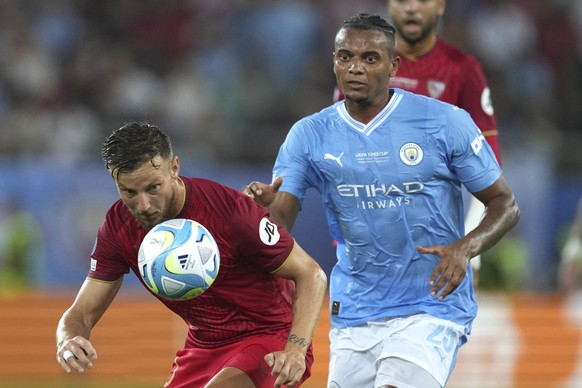 Sevilla's Ivan Rakitic, left, challenges for the ball with Manchester City's Manuel Akanji during the UEFA Super Cup final soccer match between Manchester City and Sevilla at Georgios Karais ...