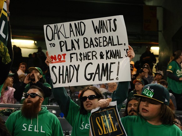 MLB, Baseball Herren, USA Cincinnati Reds at Oakland Athletics Apr 28, 2023 Oakland, California, USA An Oakland Athletics fan holds a sign in reference to owner John Fisher and president Dave Kaval no ...