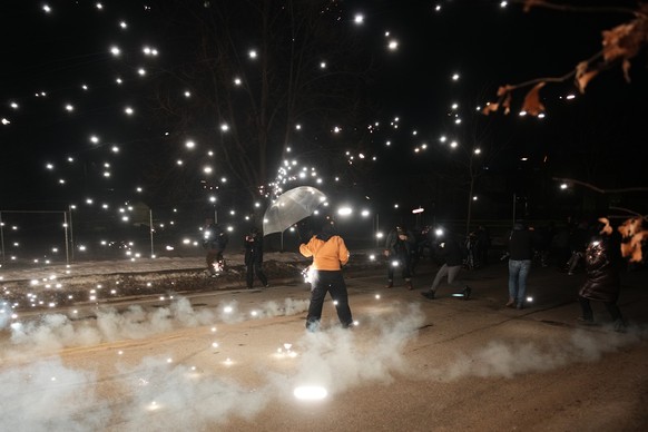 A protester holds an umbrella as sparks fly from a flash bang deployed by law enforcement on Wednesday, Jan. 14, 2026, in Minneapolis. (AP Photo/Adam Gray)
Immigration Enforcement Minnesota