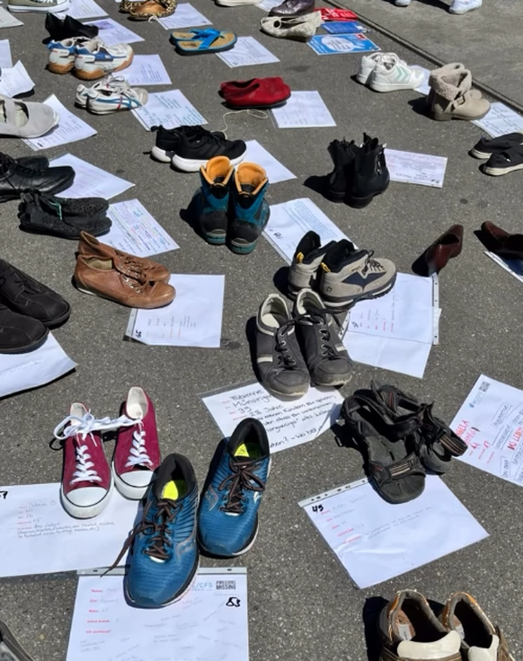 Menschen stellten Schuhe für Personen auf, die erkrankt sind.