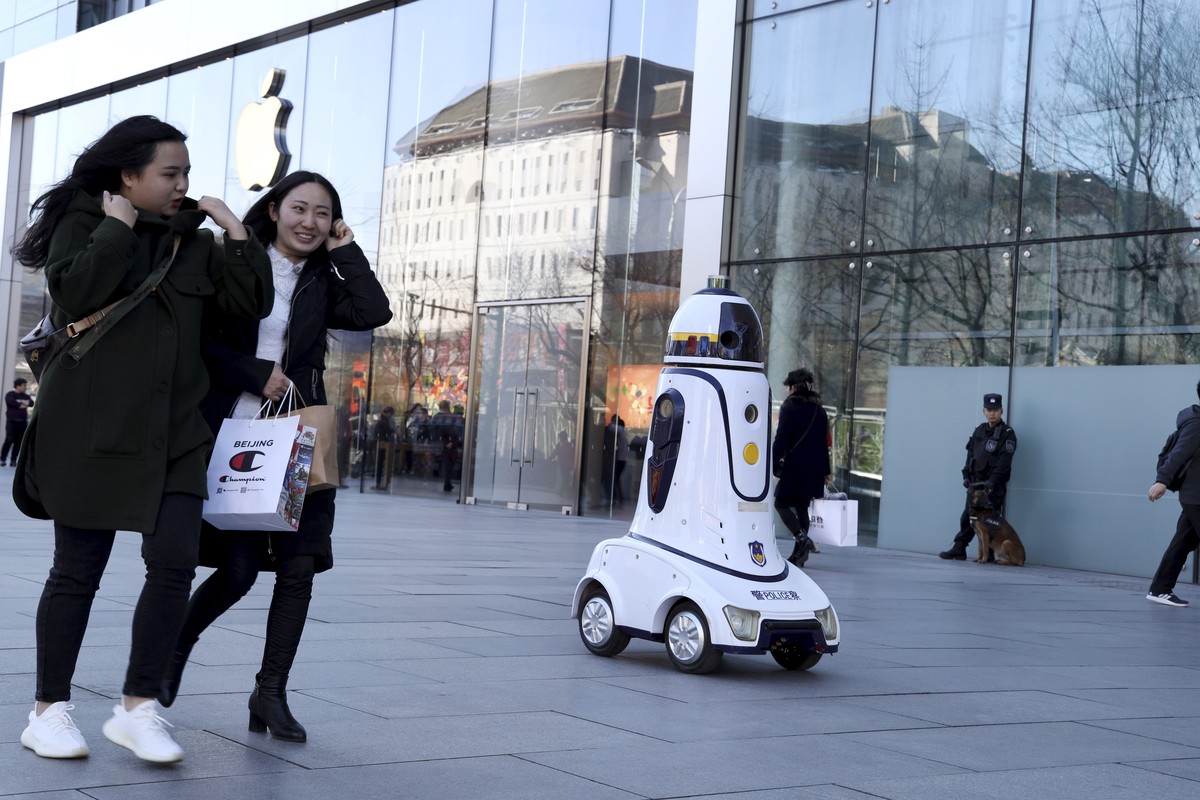 A police robot is stationed near an Apple store in Beijing, China, Wednesday, March 6, 2019. China's emergence as a competitor in key technologies such as smartphones and telecoms equipment has r ...