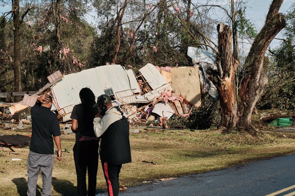 epa10402292 People look at a trailer devastated after a tornado touched down in Mount Vernon, Alabama, United States, on Jan. 12, 2023. EPA/DAN ANDERSON