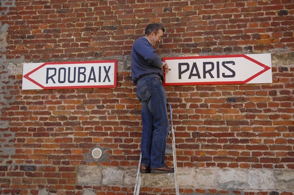 Bildnummer: 04697190 Datum: 25.03.2007 Copyright: imago/Felix Jason
Helfer bringt Schilder für das Radrennen Paris Roubaix an; Vdig, quer, Wegweiser, Schriftzug, Schild, Paris Roubaix 2007, ProTour, S ...