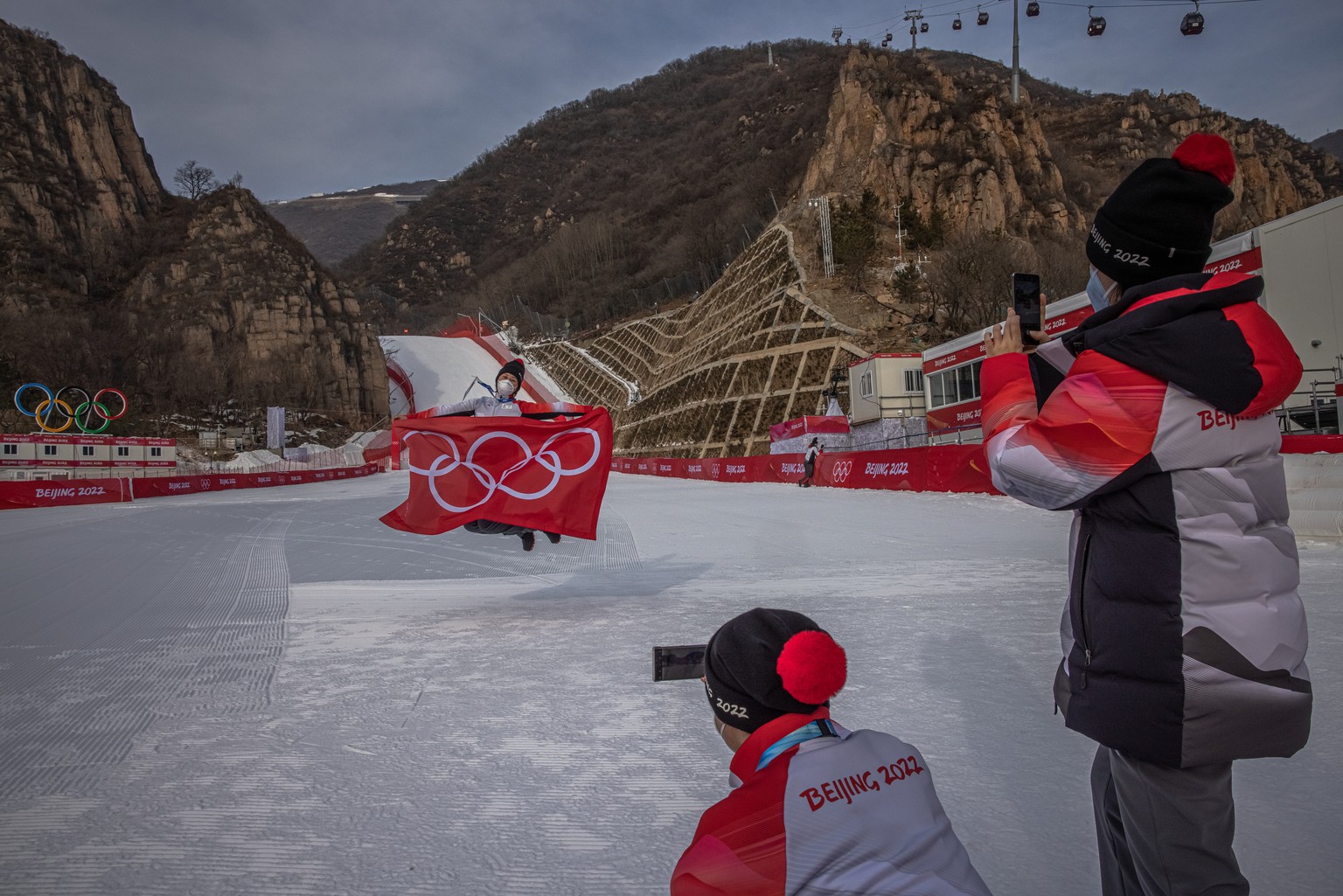 epa09718218 An Olympic staff poses for a photo at Yanqing National Alpine Skiing Center, the Olympic venue for alpine skiing, in Beijing, China, 30 January 2022. The Beijing 2022 Winter Olympics is sc ...