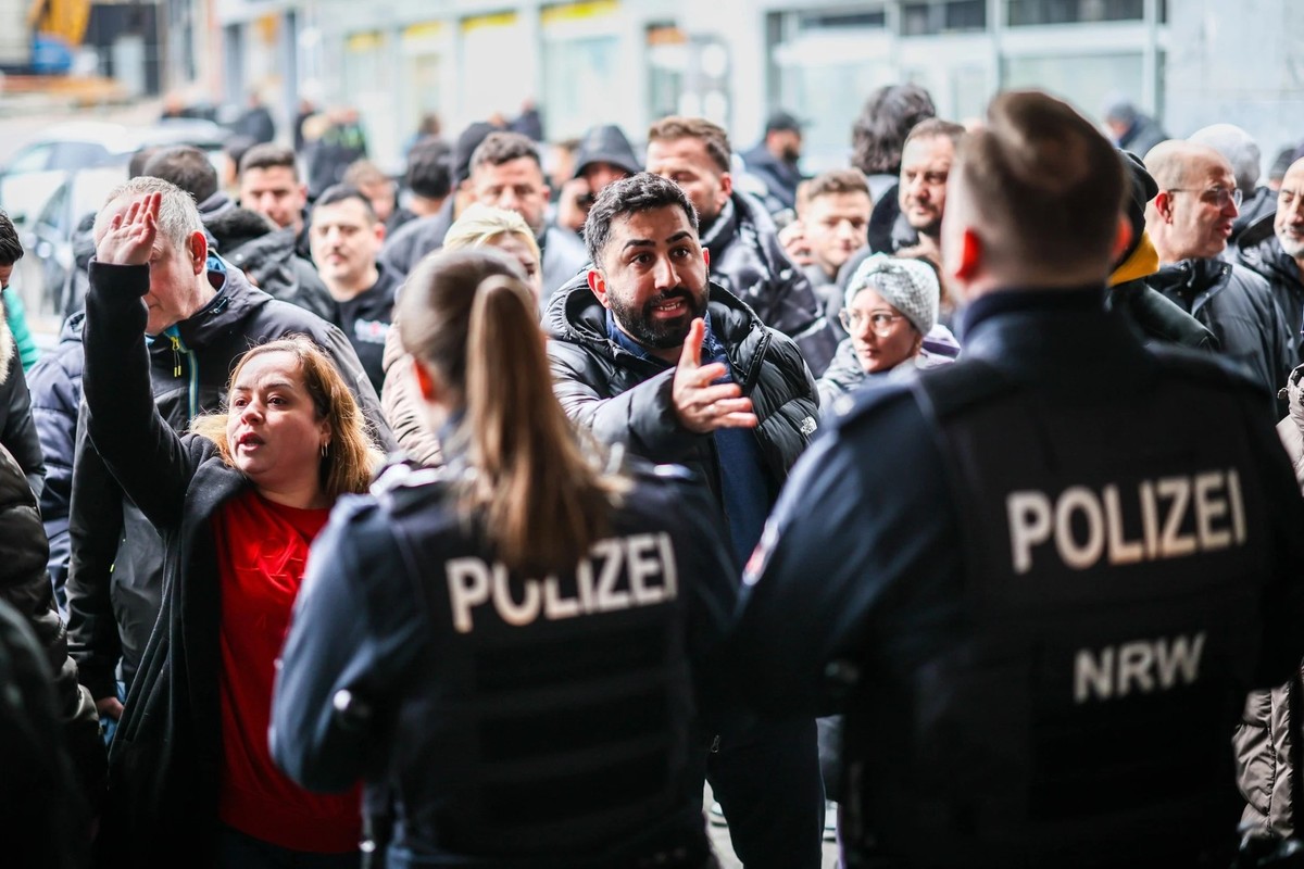 Aufgebrachte Demonstranten verlangen Zutritt zur von einem Polizei-Kordon abgesicherten Sparkassenfiliale.