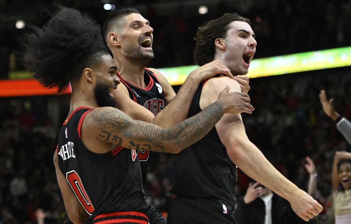 Chicago Bulls' Josh Giddey right, celebrates with teammates Nikola Vucevic center, and Coby White left, after making the winning basket against the Los Angeles Lakers in an NBA basketball game Th ...