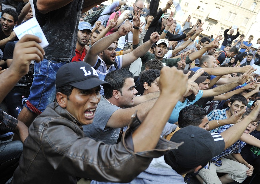 epa04907458 Migrants protest in front of the Keleti Railway Station after police closed the station in Budapest, Hungary, 01 September 2015. Hungarian police closed the main train station in Budapest  ...