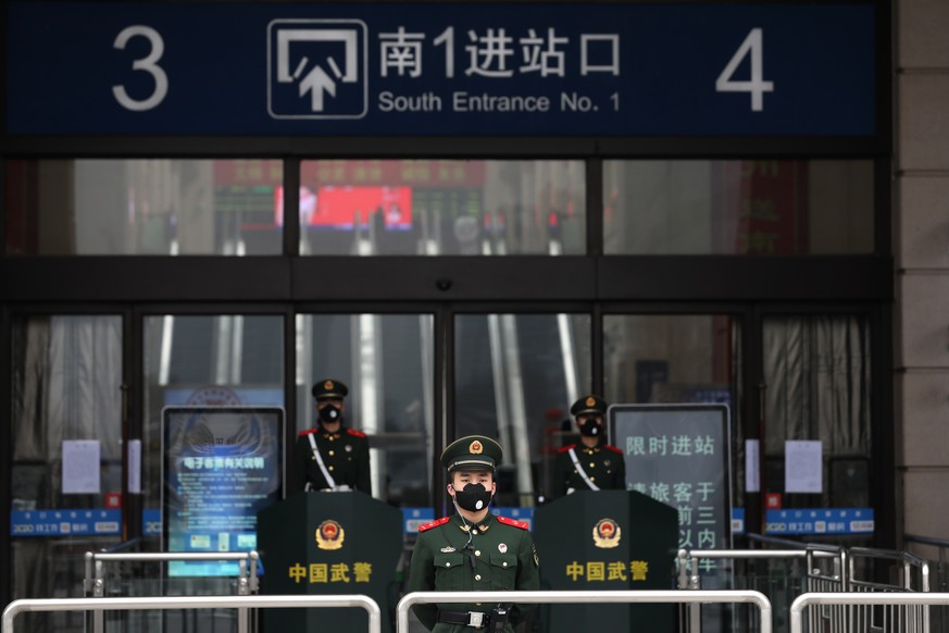 epa08154425 Paramilitary policemen guard outside the closed Hankou Railway Station in Wuhan, central China's Hubei province, 23 January 2020. Wuhan has shut down public transportation, including ...