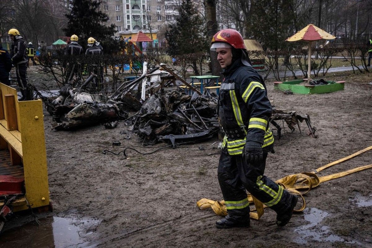 BROVARY, UKRAINE - JANUARY 18: Firemen roll up hoses in front of debris as emergency service workers respond at the site of a helicopter crash on January 18, 2023 in Brovary, Ukraine. Eighteen people  ...