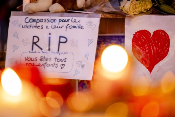 epa12626285 Flowers and candles are pictured in tribute to the victims after the fire at the 'Le Constellation' bar and lounge, in Crans-Montana, Switzerland, 04 January 2026. At least 40 pe ...