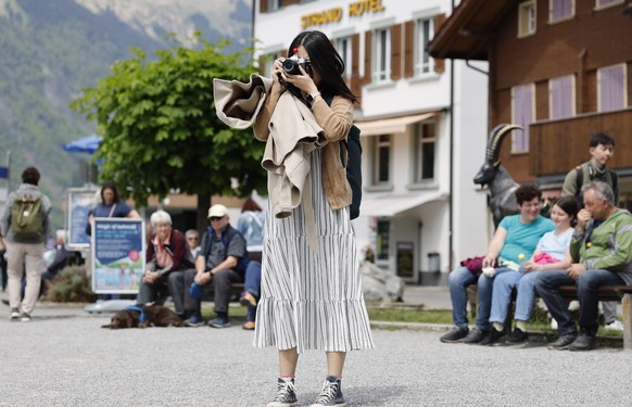 epa10643846 A Korean visitor takes pictures in Iseltwald, Switzerland, 21 May 2023. Lots of Asian TV fans and tourists visit the place because of the romantic Korean Netflix drama &#039;Crash Landing  ...