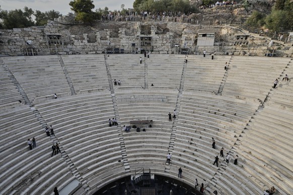 Tourists watch the ushers as they prepare the Odeon of Herodes Atticus ahead of the dress rehearsal of Giacomo Puccini&#039;s &quot;Turandot&quot; by the Greek National Opera during the 70th Athens Ep ...